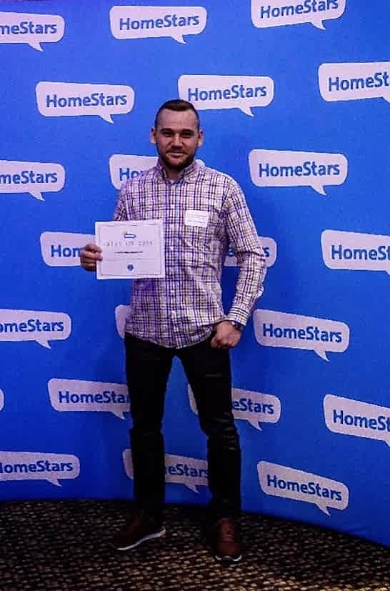 Denis Valasevich holding the HomeStars Best of 2018 certificate in front of a HomeStars branded backdrop