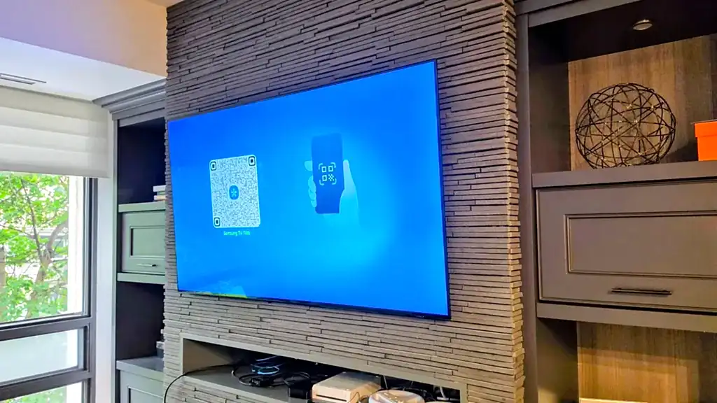 Thin OLED TV mounted close to a stacked-stone feature wall between built-in cabinets