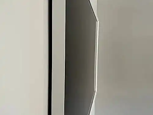 Close-up of the edge of a flush-mounted TV, showing how tight the panel sits against the wall