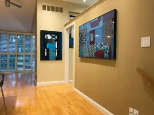 Two Samsung Frame TVs mounted along a hallway, both running artwork so they read as framed pictures