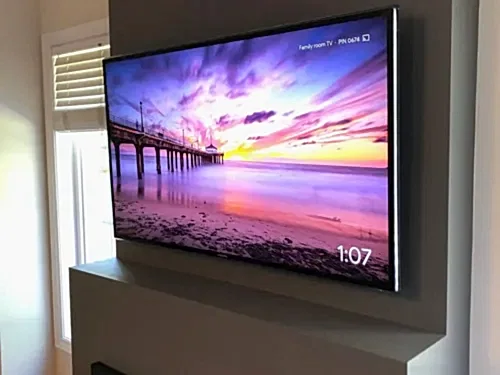 TV mounted on a projecting family room wall, angled toward the seating