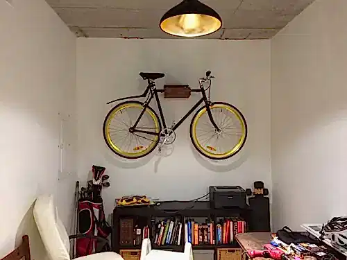 Bicycle hung on a wall mount in a basement storage room