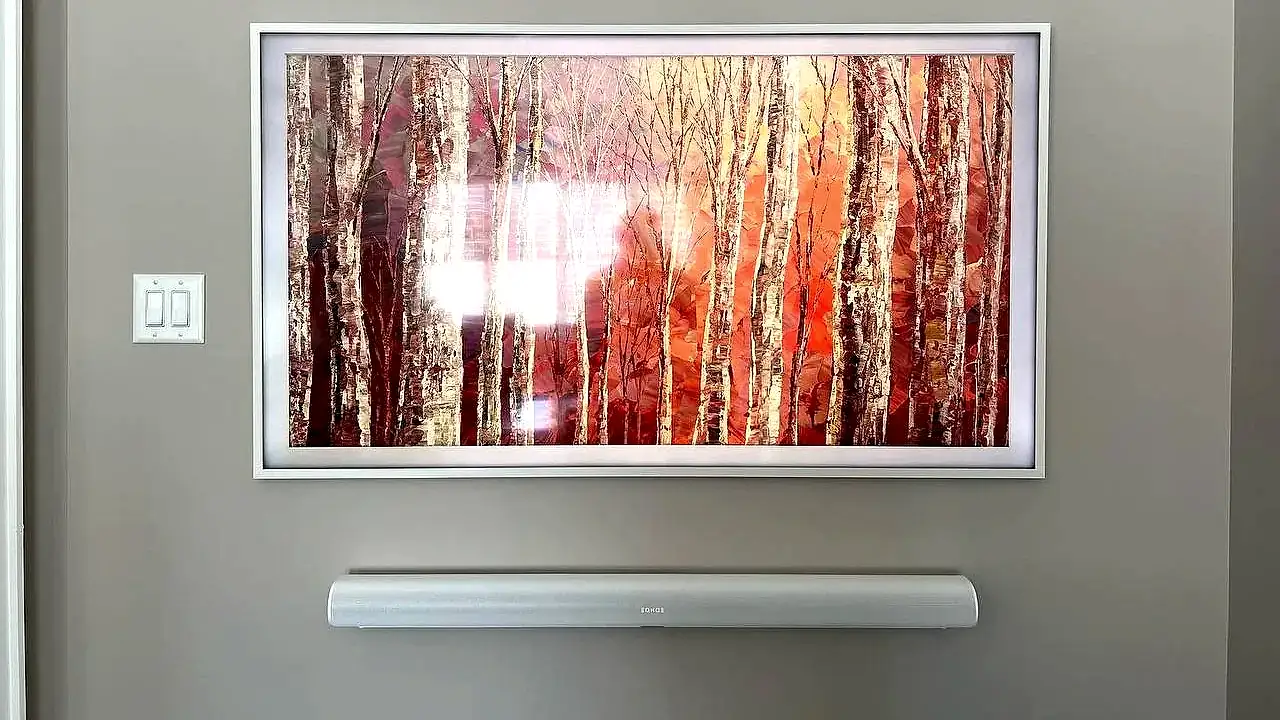 Samsung Frame TV with a white customisable bezel and a matching soundbar mounted level beneath it