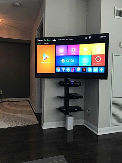 Three floating shelves installed in a stack on the wall beside a mounted TV