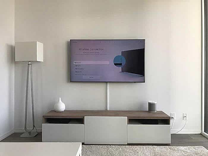 Wall-mounted TV with every cable concealed inside the wall and nothing visible below the screen